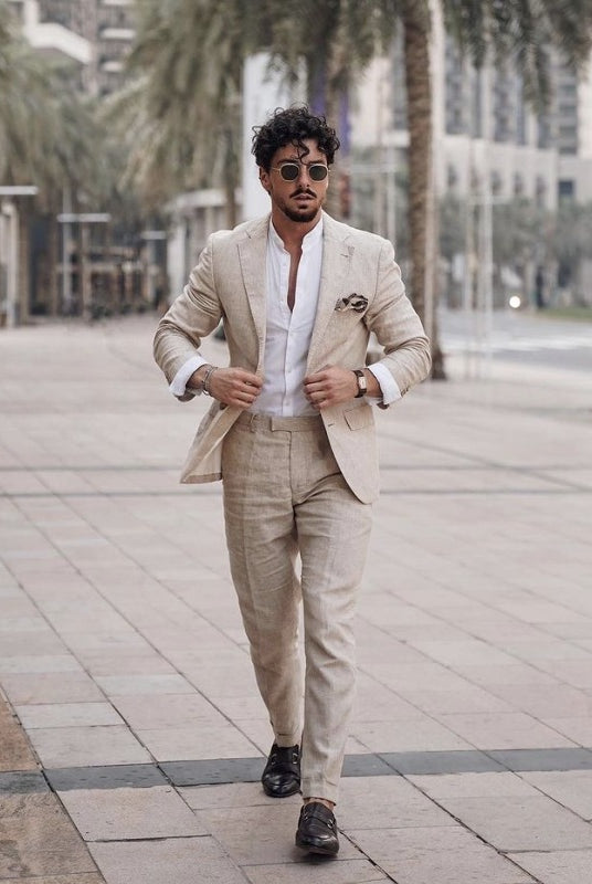A man walking outdoors in a beige linen suit